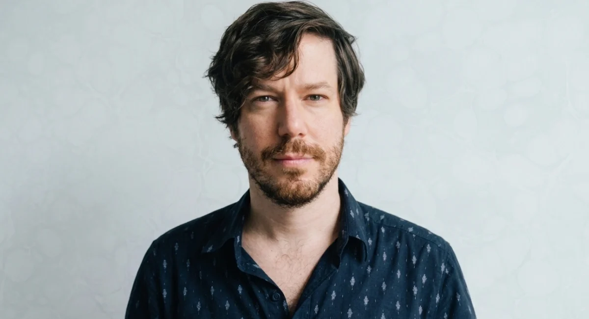 John Gallagher Jr. actor and musician performing on Broadway stage with acoustic guitar