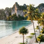 Scenic view of Ao Nang Beach with limestone karsts, turquoise water, and beachfront resorts in Krabi Thailand