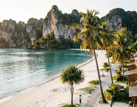 Scenic view of Ao Nang Beach with limestone karsts, turquoise water, and beachfront resorts in Krabi Thailand