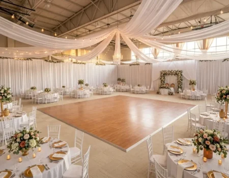 Gym floor covered with protective carpet and portable wood-grain dance floor for a wedding